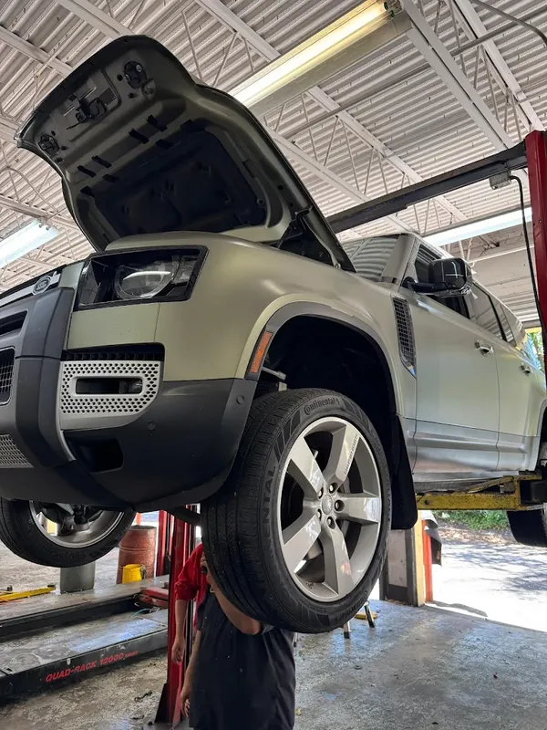 Land Rover Defender raised on a lift for suspension and undercar work