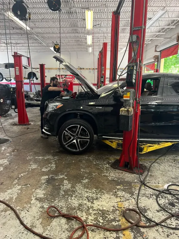 Mercedes SUV raised in a full-service repair bay at AutoPlus